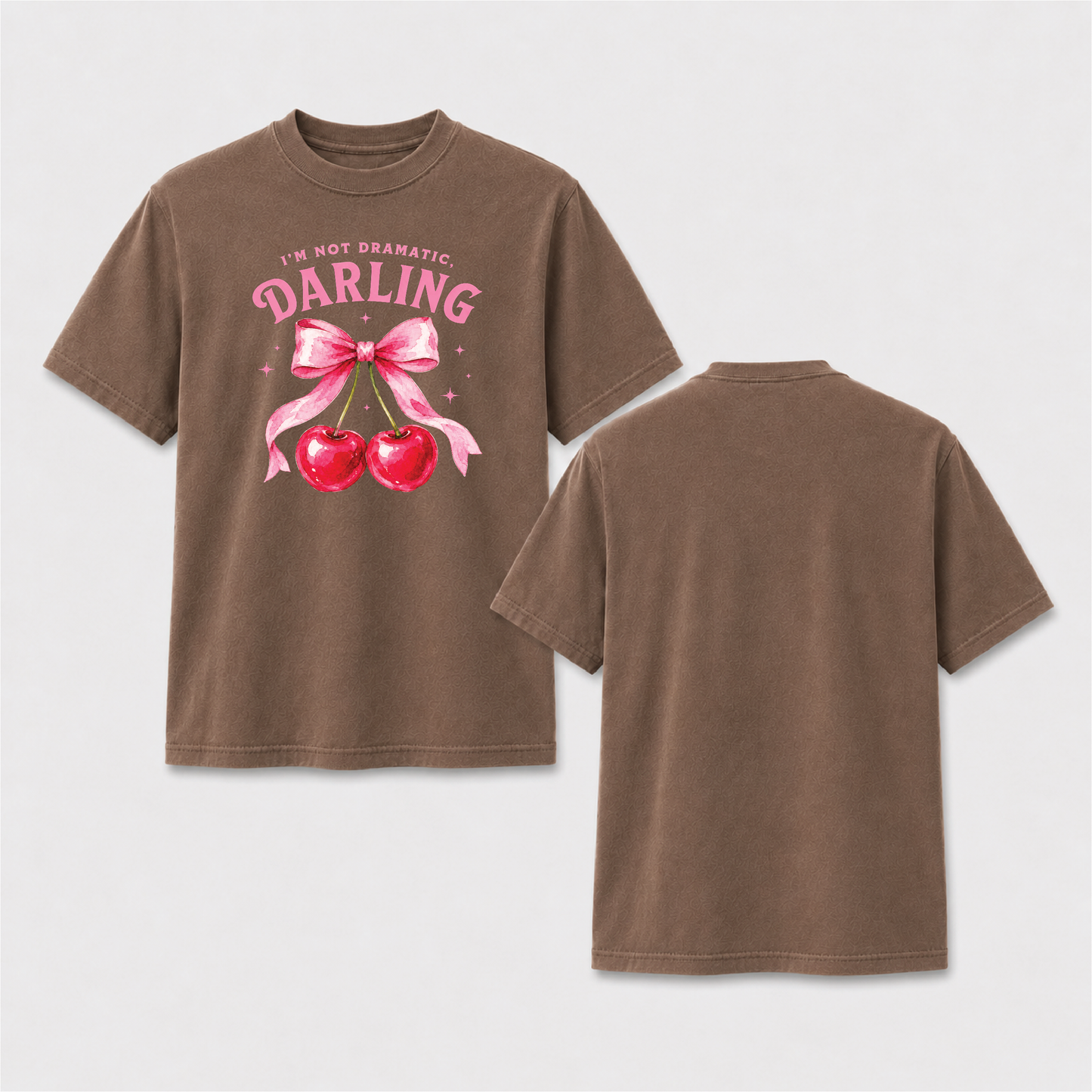 Front and back view of a white T-shirt with pink I’m Not Dramatic Darling lettering, watercolor red cherries and an oversized pink bow on the front.